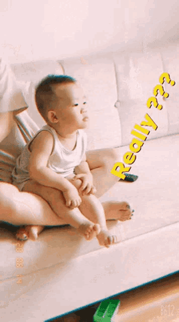 a baby is sitting on a woman 's lap with the words " really " behind him