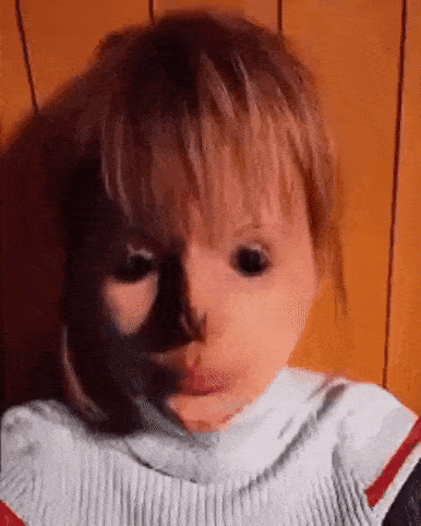 a close up of a little girl 's face with a shadow on it .