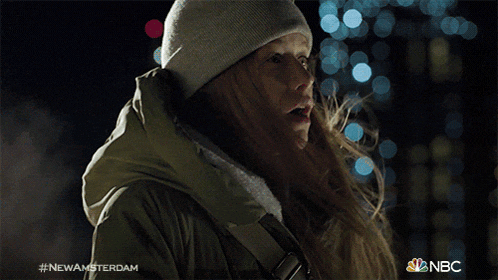 a woman wearing a beanie and a jacket with the hashtag #newamsterdam on the bottom