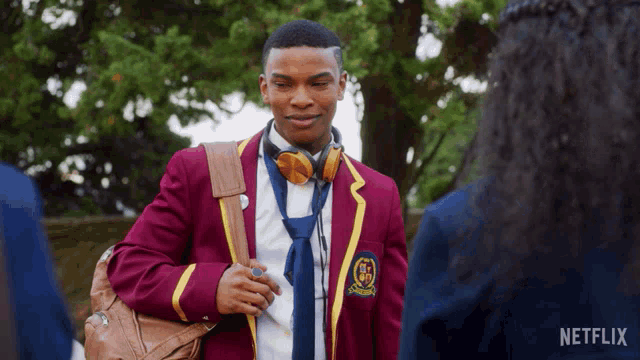 a man in a school uniform with headphones and a netflix logo behind him