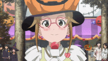 a girl wearing a hat with a pumpkin on it is smiling