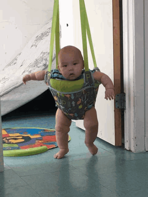 a baby in a bouncer with the word " up " on the front
