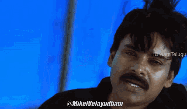 a close up of a man 's face with the hashtag @mikelvelayudham on the bottom right