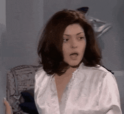 a woman in a white robe looks surprised and shocked
