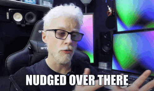 a man with white hair and glasses says " nudged over there " in front of a computer