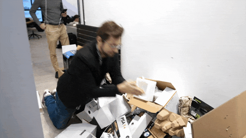 a man is kneeling down in front of a pile of boxes one of which says psa on it