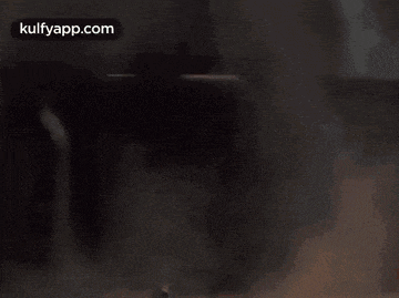 a man is holding a rocket launcher in front of a fire .