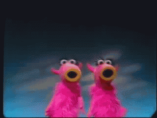 a couple of pink stuffed animals are standing next to each other