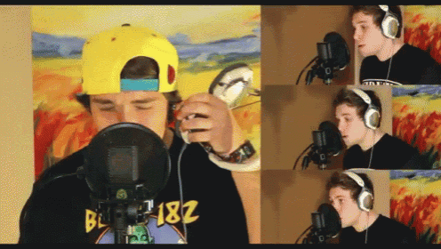 a man wearing headphones is singing into a microphone while wearing a bl 182 shirt