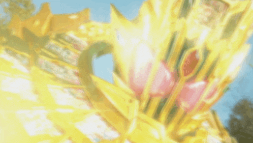 a blurred image of a gold object with a blue sky behind it