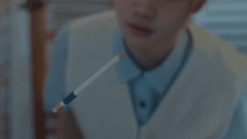 a person is holding a pencil in their mouth .