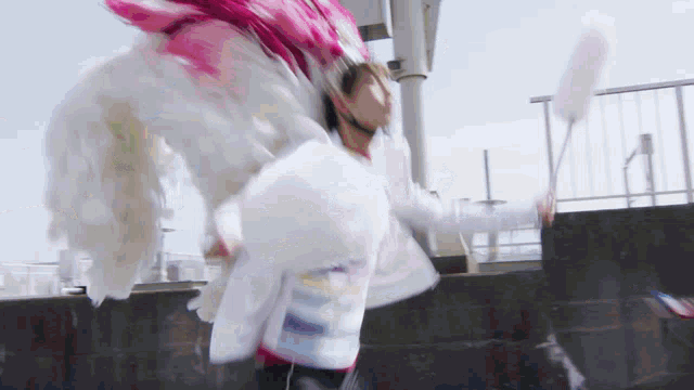 a person wearing a pink and white feathered hat and wings