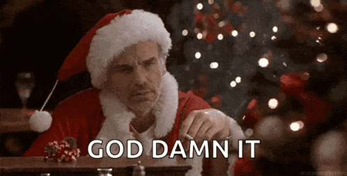 a man dressed as santa claus is smoking a cigarette in front of a christmas tree and says god damn it