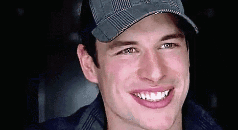 a close up of a man wearing a hat smiling .