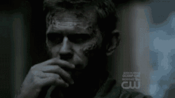 a close up of a man 's face with a cw logo on the bottom right