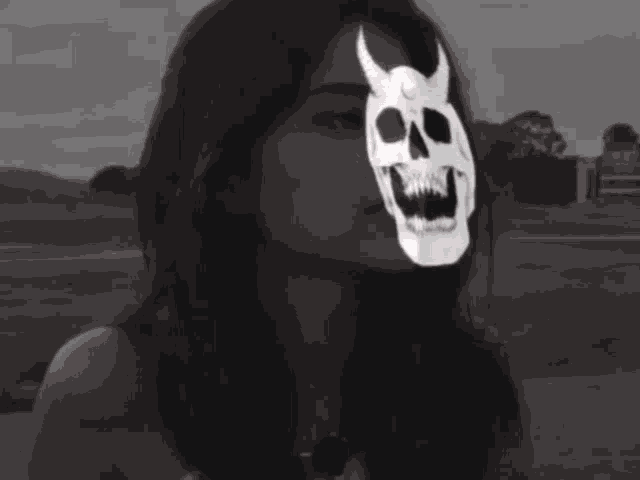 a woman with a skull on her face looks at the camera