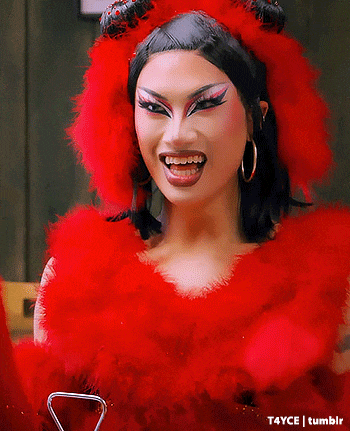 a woman is wearing a red devil costume and smiling at the camera .