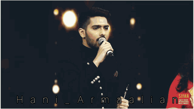 a man is singing into a microphone with the name hani armalian on the bottom