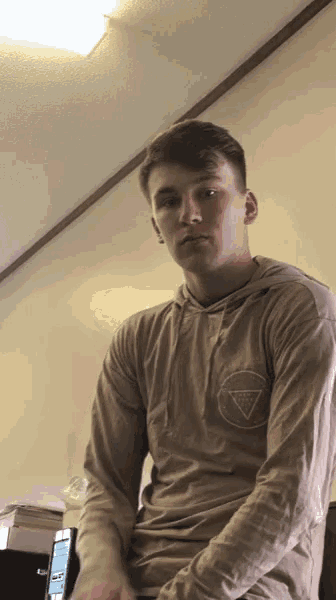 a young man wearing a hoodie with a guess logo on it