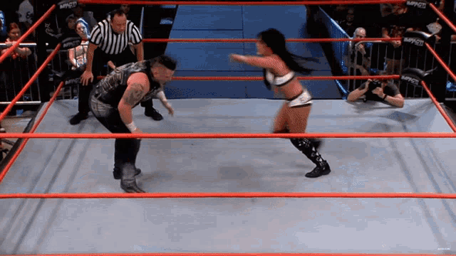 a man and a woman in a wrestling ring with the word impact on the ropes