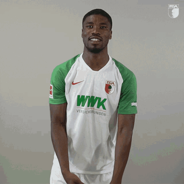 a man wearing a wwk versicherungs shirt stands with his eyes closed