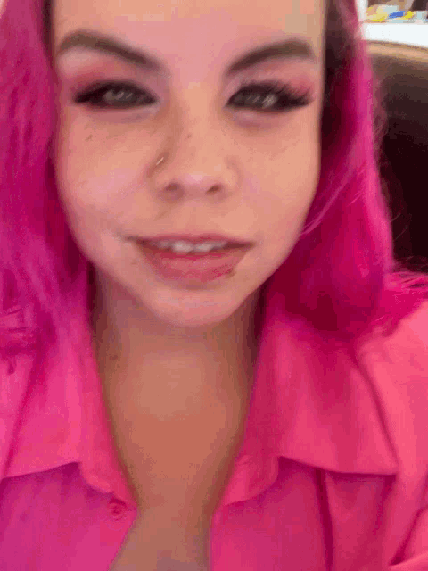 a close up of a woman with pink hair