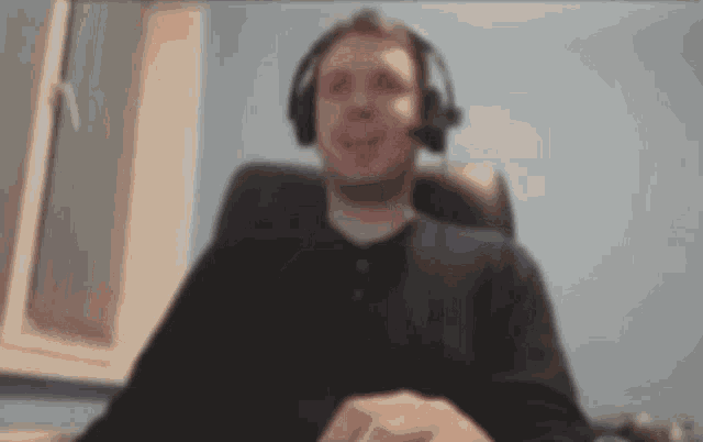 a blurry picture of a man wearing headphones and smiling