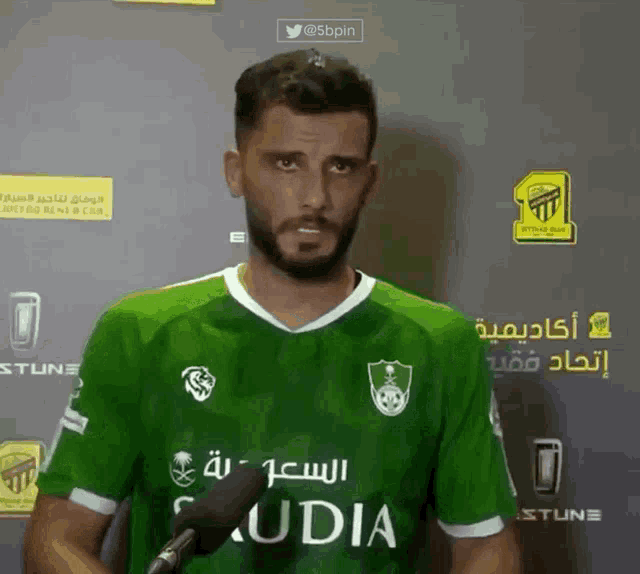 a man wearing a green jersey that says saudia on it