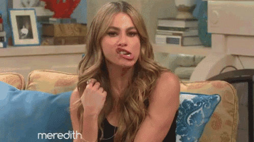 a woman is sitting on a couch with her tongue out