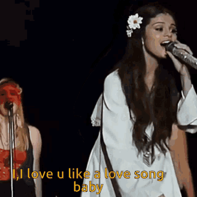 a woman singing into a microphone with the words " i love u like a love song baby "