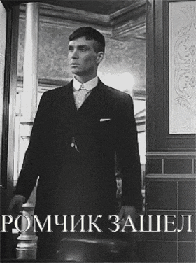 a black and white photo of a man in a suit with the words " romchik zachel " on the bottom
