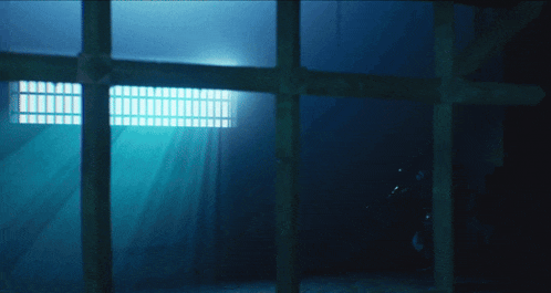 a dark room with a light shining through a window