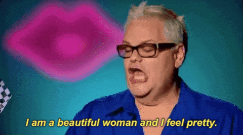 a woman wearing glasses and a blue shirt is saying i am a beautiful woman and i feel pretty