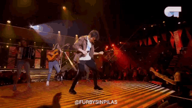 a group of people playing instruments on a stage with the words furbysinpilas on the bottom right