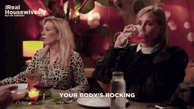 two women sitting at a table with a real housewives logo