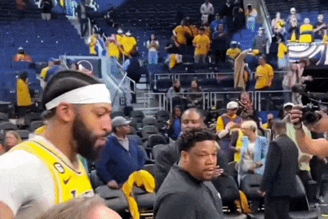 a basketball player wearing a headband is standing in the stands of a stadium .