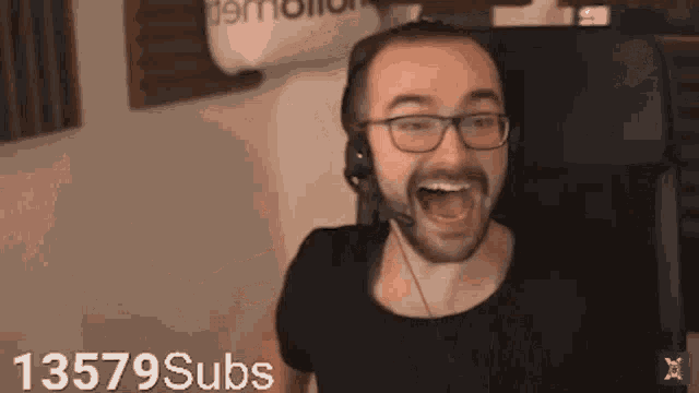 a man wearing glasses and headphones is covering his nose with his hand ..