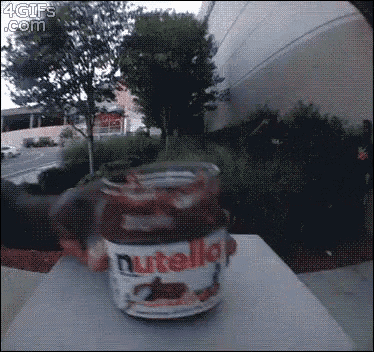a person is holding a jar of nutella on a table