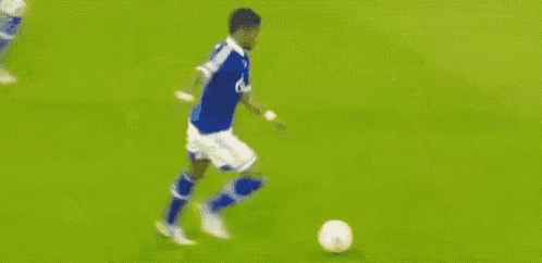 a blurry picture of a soccer field with a sign that says s04shop.de in the background