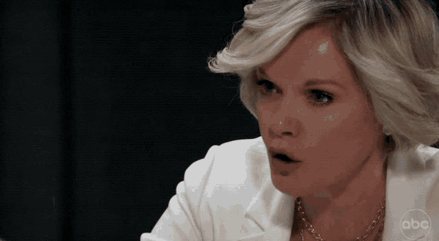 a woman in a white jacket with the abc logo on the bottom right