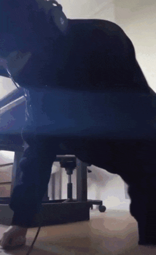 a person is doing push ups under a desk with headphones on
