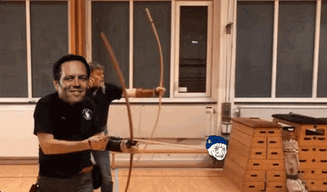 a man is holding a bow and arrow in a room