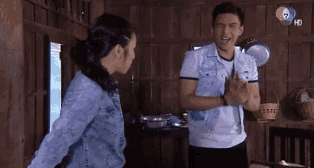 a man and woman are standing next to each other in a wooden house .