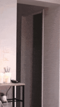 a candle sits on a table in front of a door that is open