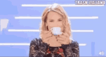 a woman is drinking a cup of coffee and the words trash italiano are above her