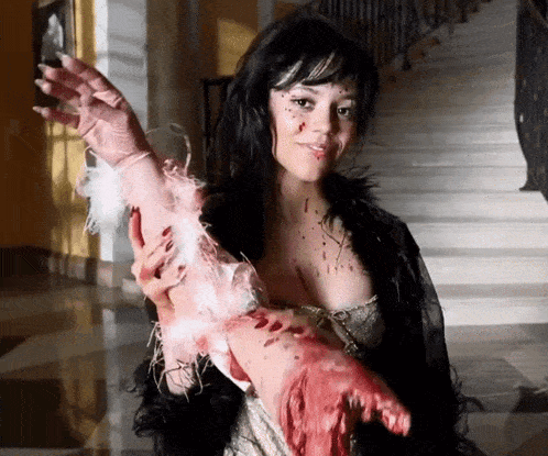 a woman is holding a bloody arm with feathers