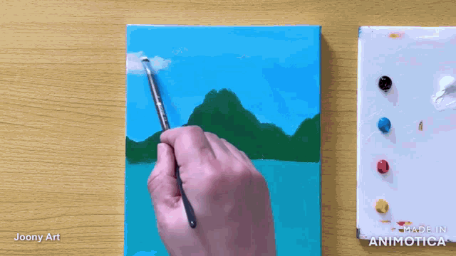a person is painting a landscape on a canvas with the words made in animatica visible