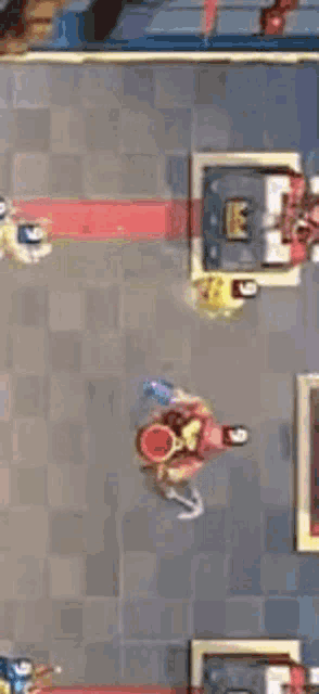 a group of people are playing a game of clash of clans on a tiled floor .