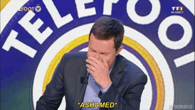 a man covering his mouth with his hand in front of a logo for telefoot