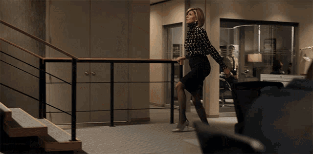 a woman in a black skirt is standing on a railing